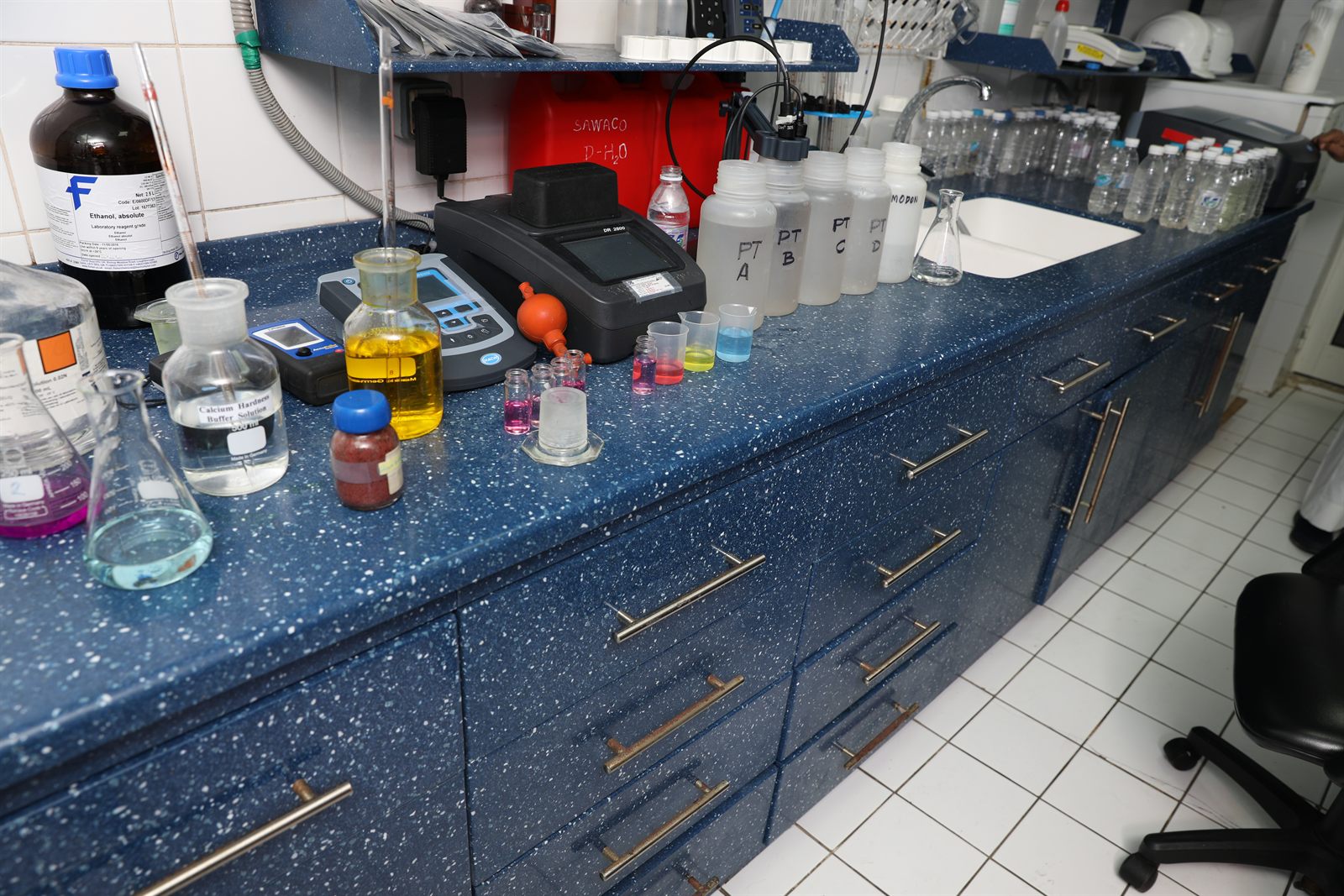 Laboratory workbench with reagents, spectrophotometer and sample bottles